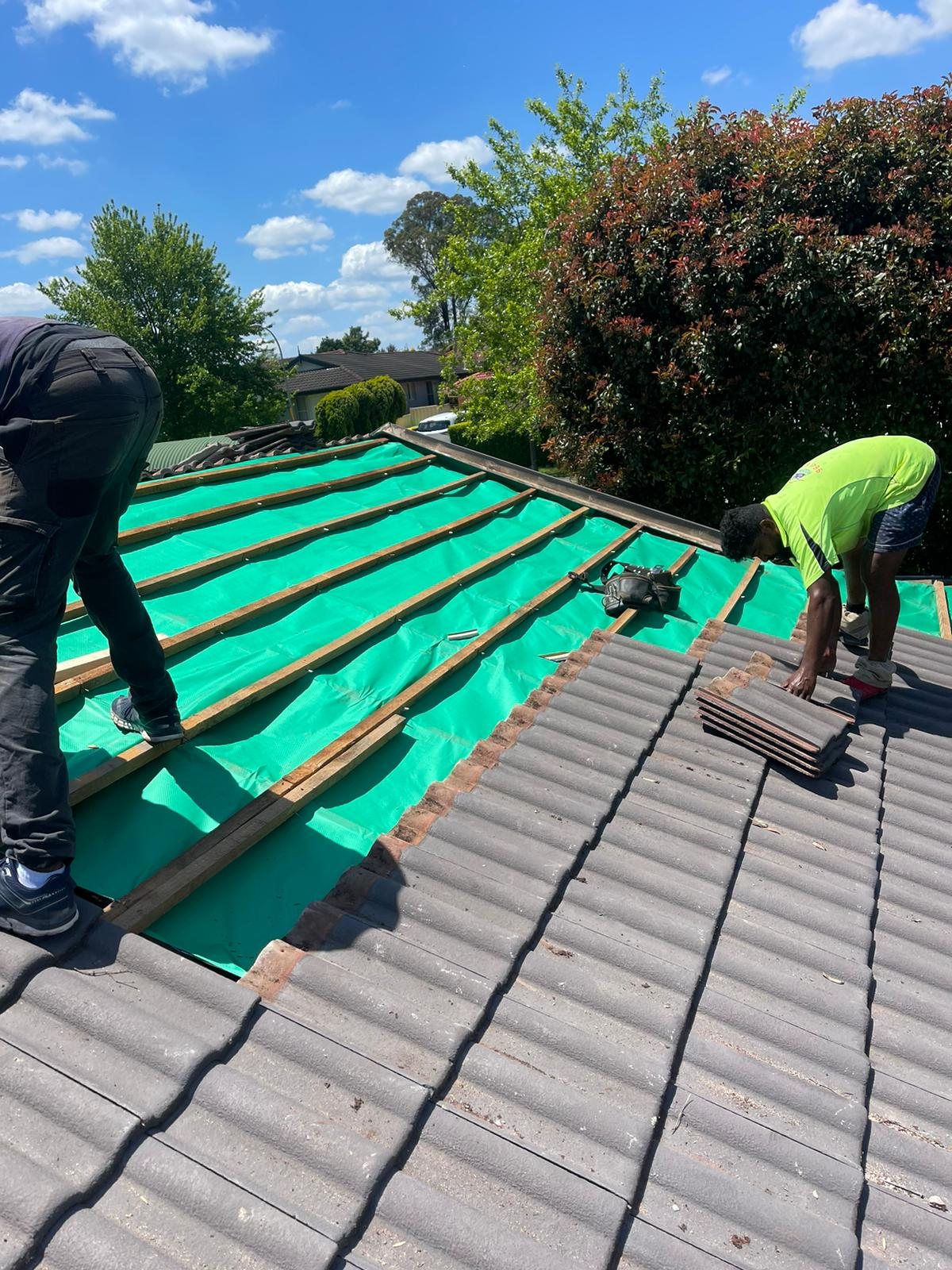 Crew installing new sarking and battens on a roof